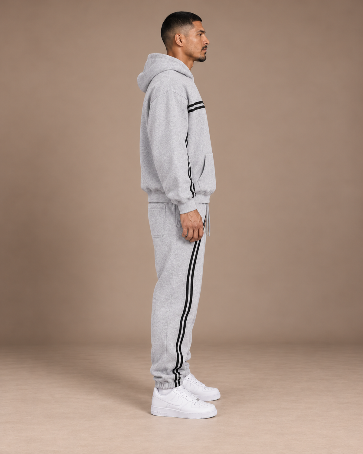 Male model wearing the Flower Gray TLOL Threshold hoodie and matching joggers, right side view