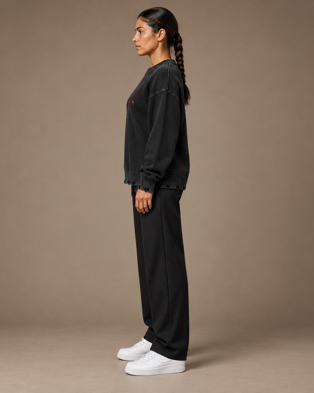 Female model wearing TLOL Black frayed sweater, left view