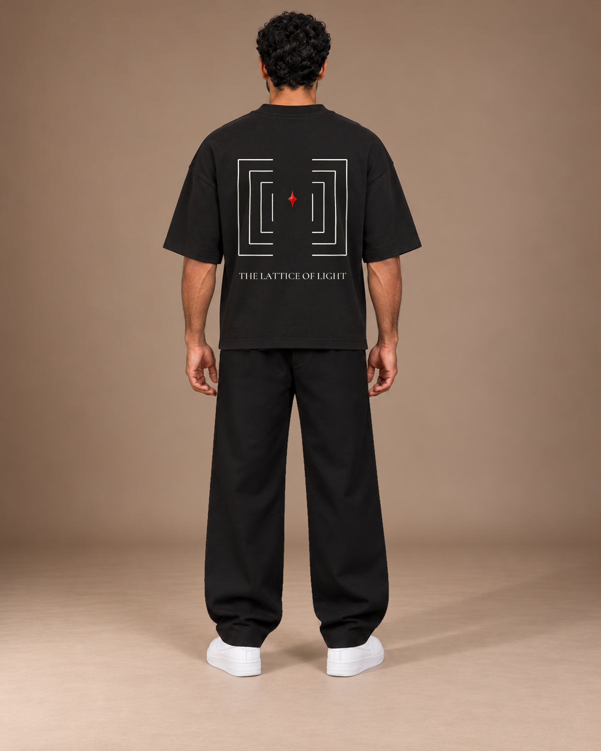 TLOL Lightwell oversized tee in Black, back view on a model showing the geometric artwork.