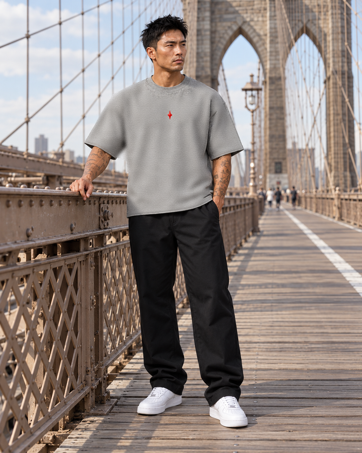 TLOL Lightwell oversized tee in Flower Gray, model styled with black trousers in a Brooklyn Bridge-inspired scene.