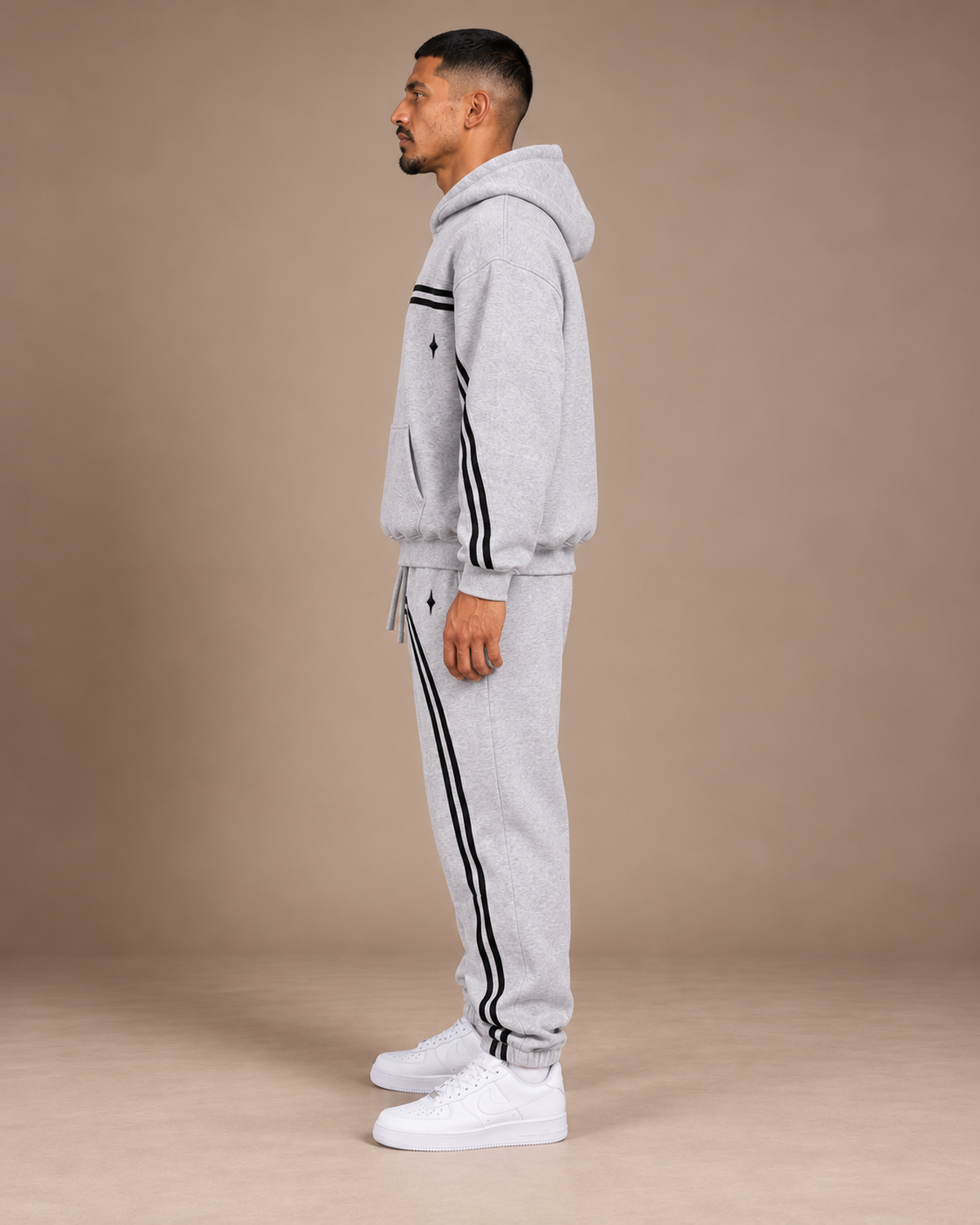 Male model wearing the Flower Gray TLOL Threshold hoodie and matching joggers, left side view